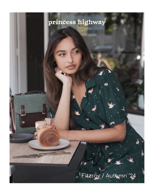 Beautiful girl with a croissant wearing a dress with ducks printed on it